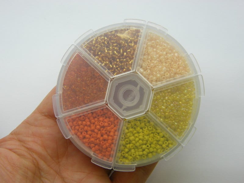 1 Storage box with 6 different orange yellow 2mm seed beads