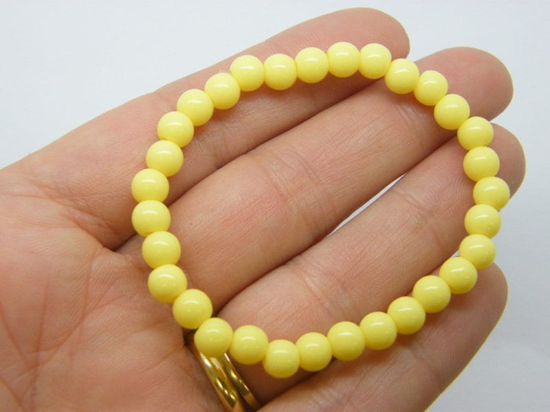 6 Yellow beaded bracelets elasticated