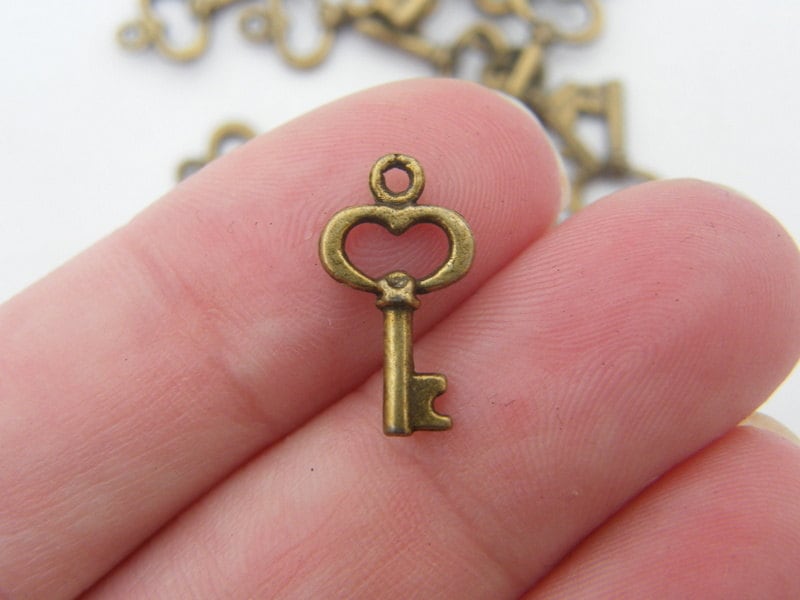 16 key charms antique bronze tone K69