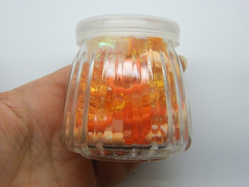 1 Glass bottle jar with plastic lid 6.85 x 6.8cm with random orange beads